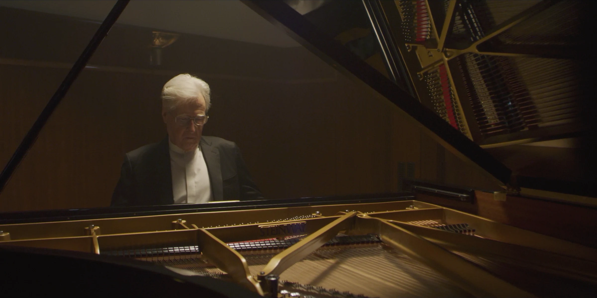 Pianist framed by the grand piano and its reflection
