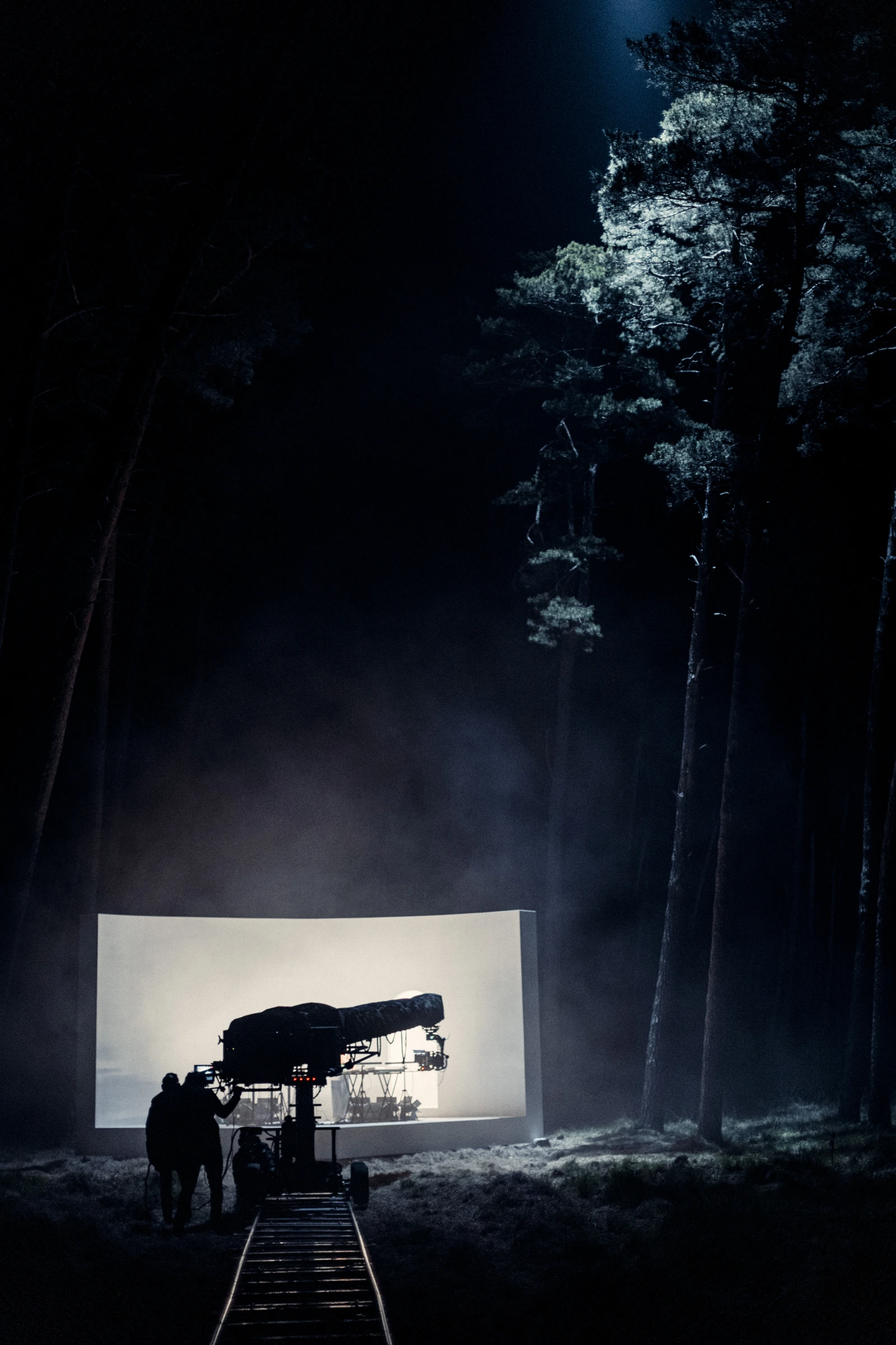 Camera crane and illuminated forest stage at night