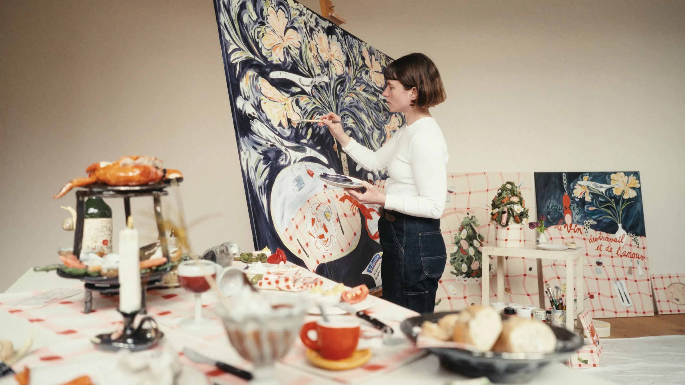 Philippine painting a floral canvas in her studio