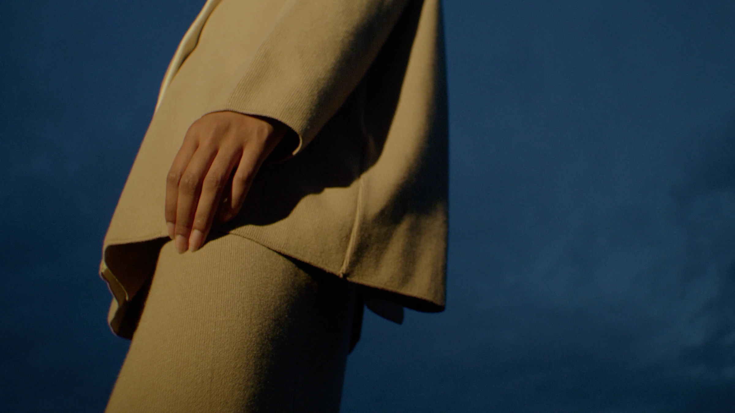 Hand and tailored cuff against the blue sky